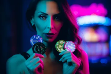 A woman smiling by bright slot machines showing lucky symbols, showcasing the exciting slot offerings at ALWAFA.